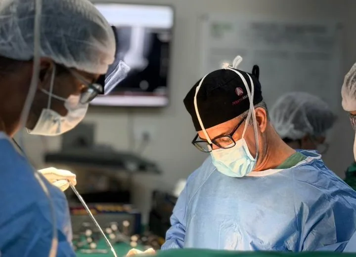 Dr. Ulbiramar Correia durante cirurgia de joelho, ao lado da equipe, no centro cirúrgico em Goiânia